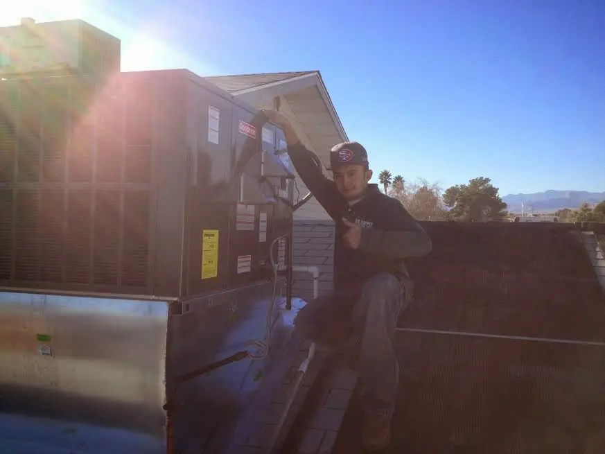 HVAC technician performing AC Tune-Up on a rooftop unit in Shelbyville